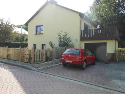 a red car parked in front of a house at Ferienwohnung Frohmut in Burg Stargard