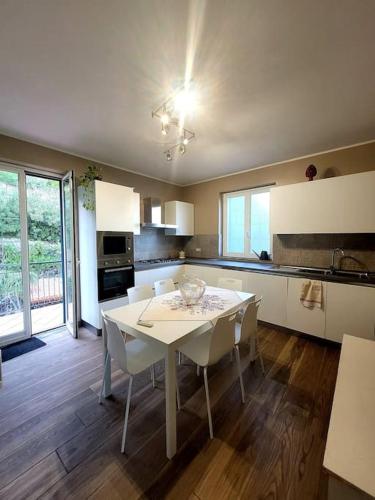 a kitchen with a white table and white chairs at Terrazza sul mare in Scaletta Zanclea