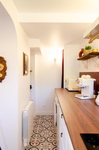 a kitchen with white walls and a wooden counter top at Retro Reverie, avec parking gratuit et terrasse in Ban-Saint-Martin