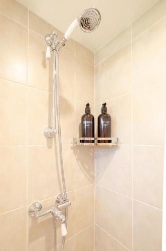 a shower in a bathroom with two bottles at Retro Reverie, avec parking gratuit et terrasse in Ban-Saint-Martin