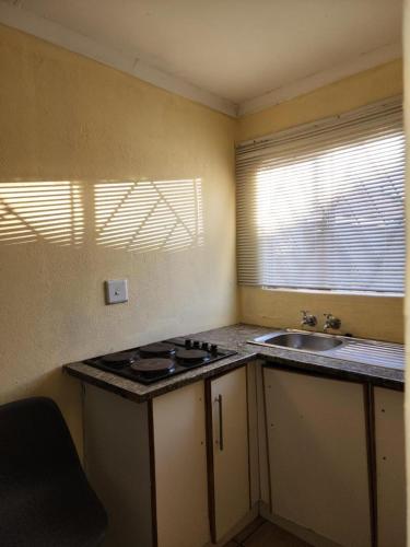 a small kitchen with a sink and a stove at Zone 4 Motel and spa in Polokwane