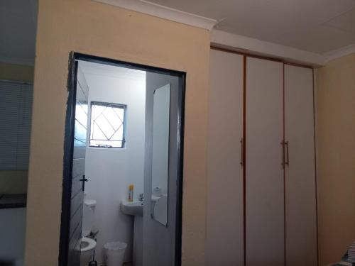a bathroom with a shower and a toilet and a mirror at Zone 4 Motel and spa in Polokwane