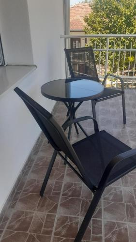 a black chair and a table on a patio at Udobna Dvokrevetna Soba Sa Terasom #2 in Mladenovac