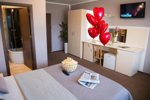 a room with a table with red heart balloons on it at MBI Travel Inn in Craiova