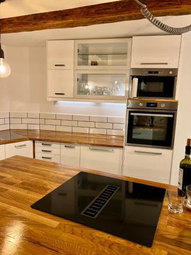 a kitchen with white cabinets and a stove top oven at Celle Old Town Hideaway in Celle