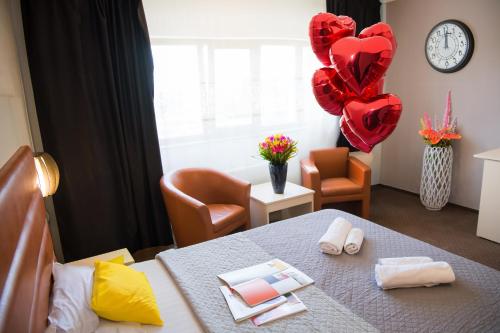 a room with a table with hearts and balloons at MBI Travel Inn in Craiova