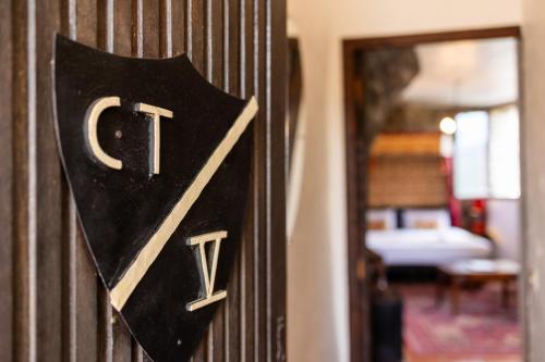 a door sign with the letter v on a wall at Château de Trigance in Trigance