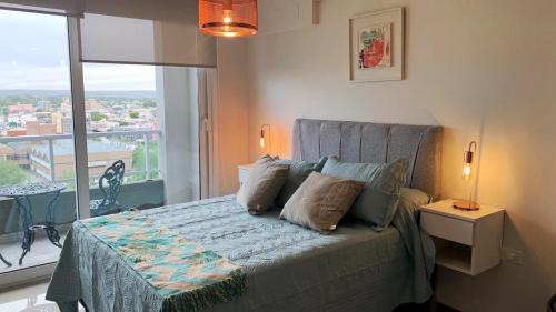 a bedroom with a bed with a large window at Departamento Parque - Neuquén in Neuquén