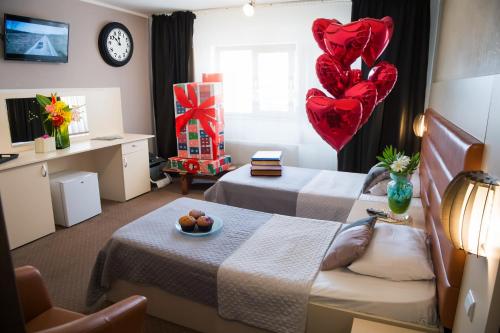 a bedroom with two beds and two heart balloons at MBI Travel Inn in Craiova