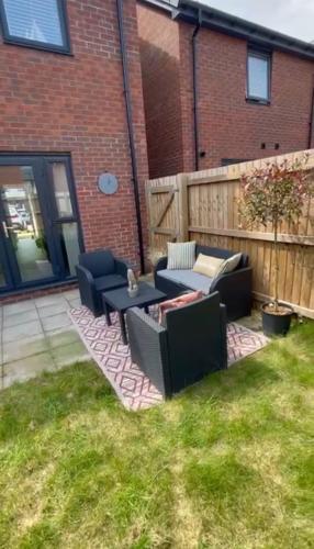 a patio with couches and a table in a yard at Barry Waterfront Stays - ENTIRE 3 BED PROPERTY in Barry