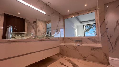 une salle de bain avec un lavabo, une baignoire et un miroir dans l'établissement Villa Vue Mer Contemporaine avec,piscine, Hammam Jacuzzi, à Mougins