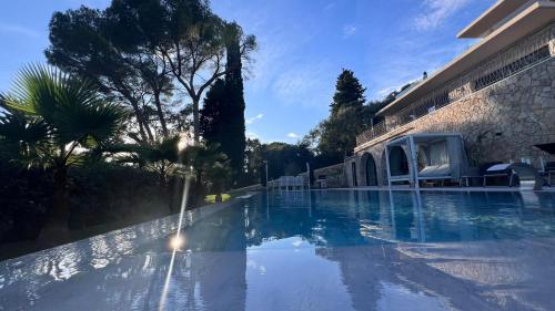une piscine avec des arbres et un bâtiment dans l'établissement Villa Vue Mer Contemporaine avec,piscine, Hammam Jacuzzi, à Mougins