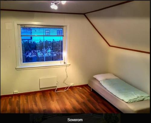 テンスベルにある2 etasje Jutulveien 6のベッドと窓のある小さな部屋