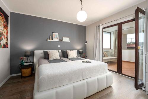 sypialnia z białym łóżkiem i przesuwnymi szklanymi drzwiami w obiekcie Holiday home in Porec - Istrien 27453 w Poreču