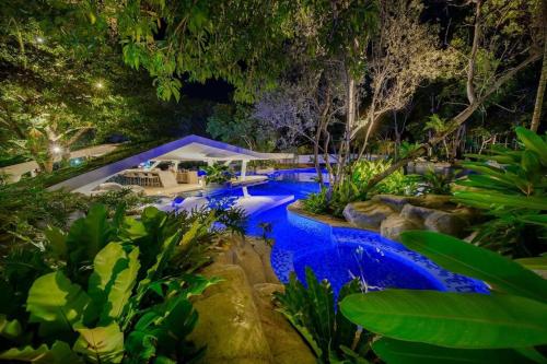 a swimming pool in a garden at night at Cerulean Bliss Condo at Tambuli Mactan Fast Wifi Netflix in Lapu Lapu City