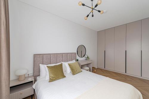 a white bedroom with a large bed with white cabinets at Charming 1 BD Apartment by Domvia in Kaunas