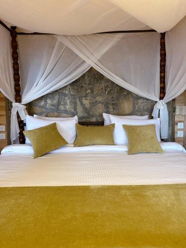 a bedroom with a large bed with a stone wall at Suuyla Kazdagları in Edremit