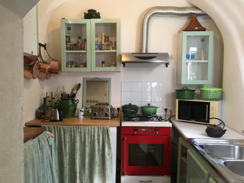 a kitchen with a red stove top oven next to a sink at Les Asphodeles chambre familiale Lilah in Saint-Hippolyte-du-Fort