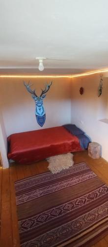 a bed in a room with a red blanket at Habitaciones Wallpari Sonqo alto hospedaje medicina temazcal in Pisac