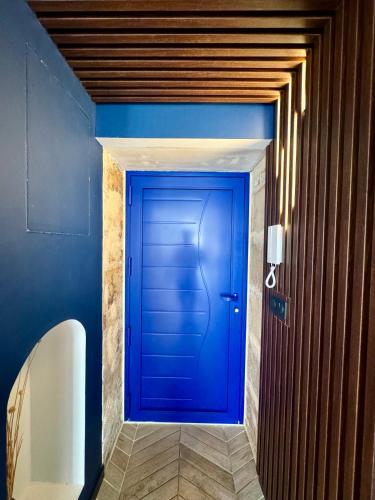a blue door in a hallway with blue walls at Roma Divine home cinéma et jardin in Nîmes