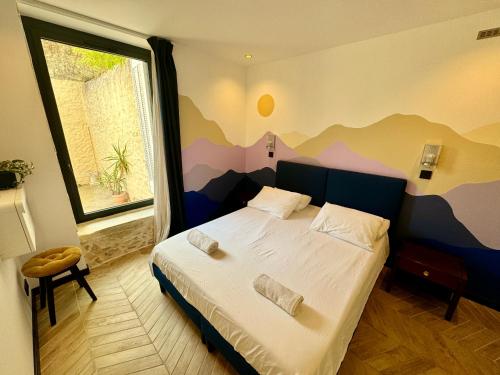 a bedroom with a bed with a mountain mural on the wall at Roma Divine home cinéma et jardin in Nîmes