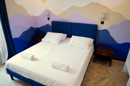 a bedroom with a bed with a mountain mural on the wall at Roma Divine home cinéma et jardin in Nîmes