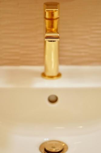 a gold bottle sitting on top of a sink at Roma Divine home cinéma et jardin in Nîmes