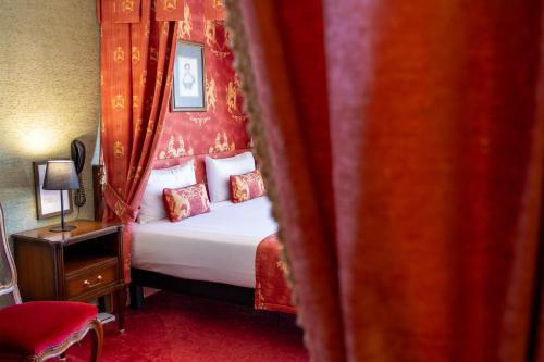 a bedroom with a bed with a red wall at Château de Trigance in Trigance