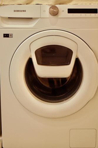 a white washing machine with a microwave on top at Roma Divine home cinéma et jardin in Nîmes
