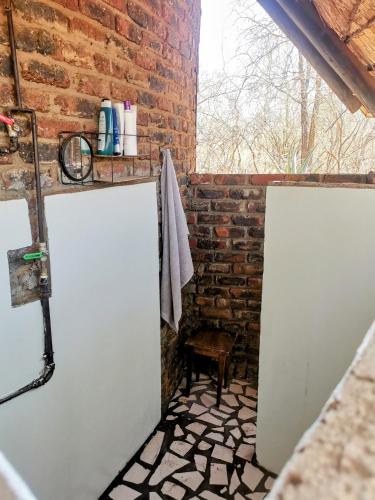 a bathroom with two white doors and a brick wall at Chip n Debs Kruger Vacations in Marloth Park