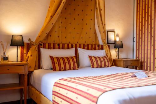 a bedroom with a large bed with a wooden headboard at Château de Trigance in Trigance