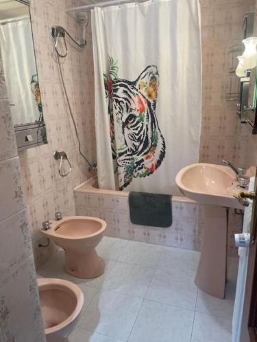 a bathroom with a tiger shower curtain and a toilet and sink at VUT Casa Albar in Soria