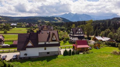 an aerial view of a house with mountains in the background at Pod Hawraniem Ski & Bike Friendly in Jurgów