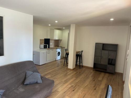 un salon avec un canapé et une cuisine dans l'établissement Appartement avec exterieur, à Le Soler