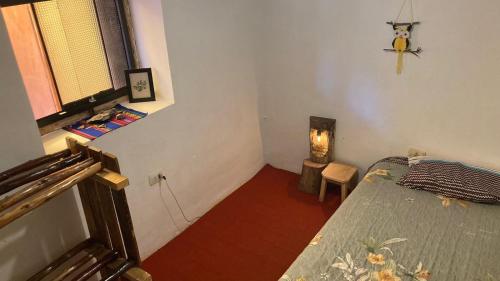 a small bedroom with a bed and a window at Habitaciones Wallpari Sonqo alto hospedaje medicina temazcal in Pisac