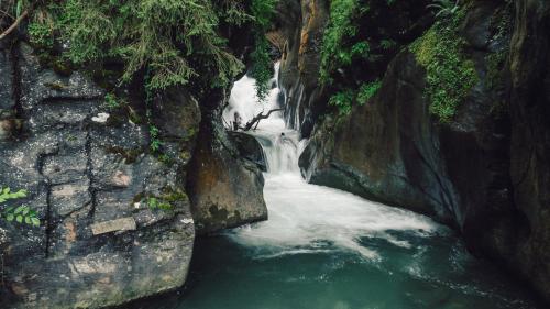 a waterfall in a river between two large rocks at Hotel - Gasthof Märzenklamm in Stumm