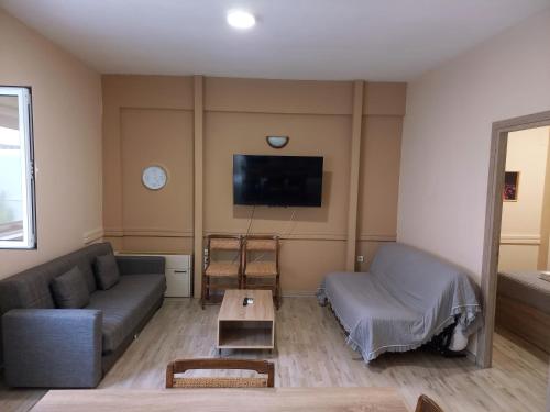 a living room with a couch and a tv at Sam's View City Heart Tripoli - Beautiful Apartment With Backyard in Tripolis