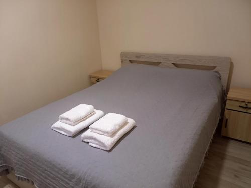 a bed with two towels on top of it at Sam's View City Heart Tripoli - Beautiful Apartment With Backyard in Tripolis