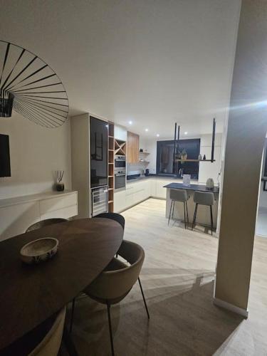 une cuisine et un salon avec une table et des chaises dans l'établissement Belle Maison avec Jardin, à Pierrelaye