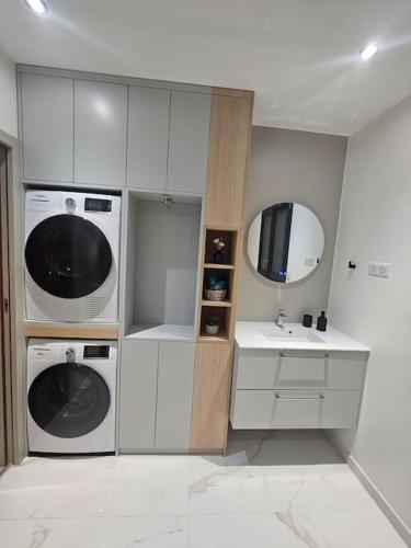 La salle de bains est pourvue de 2 lavabos, d'un lavabo et d'un miroir. dans l'établissement Belle Maison avec Jardin, à Pierrelaye