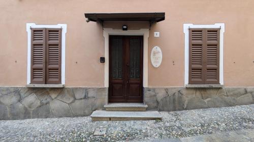 a building with a brown door and two windows at Piccolo Hotel Olina in Orta San Giulio