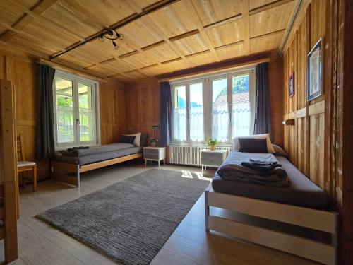 a bedroom with a bed and a couch and windows at Mountain Holiday in Wimmis