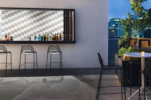 a bar with four chairs and a counter with drinks at AC Hotel by Marriott Monterrey Valle in Monterrey