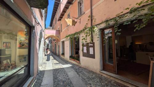 a woman walking down a street in an alley at Piccolo Hotel Olina in Orta San Giulio