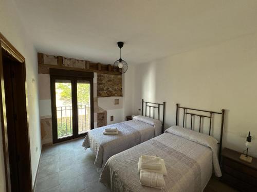a bedroom with two beds and a window at Casa Rural TorreMontero Apartamentos in Hornos el Viejo