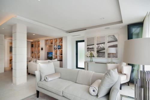 a living room with a white couch and a table at Luxury Seafront Villa Prestige Brac with private pool, sauna and gym and private sea deck at the beach on Brac island in Selca