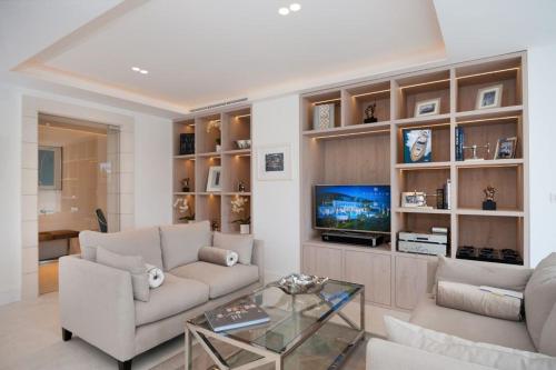 a living room with a couch and a tv at Luxury Seafront Villa Prestige Brac with private pool, sauna and gym and private sea deck at the beach on Brac island in Selca