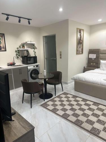 a bedroom with a bed and a table and a kitchen at Duba gold in Ḑubā