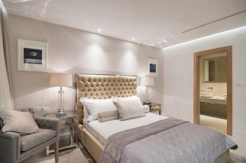 a bedroom with a large bed and a chair at Luxury Seafront Villa Prestige Brac with private pool, sauna and gym and private sea deck at the beach on Brac island in Selca