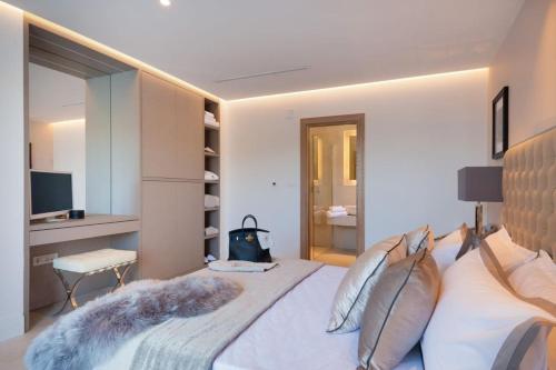 a bedroom with a large bed and a television at Luxury Seafront Villa Prestige Brac with private pool, sauna and gym and private sea deck at the beach on Brac island in Selca